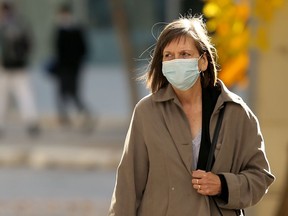 A woman wearing a mask walks in the Exchange District in Winnipeg on Thursday.