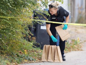 A forensics officer bags evidence during a homicide investigation on Atlantic Avenue in Winnipeg on Sunday, Oct. 11, 2020.