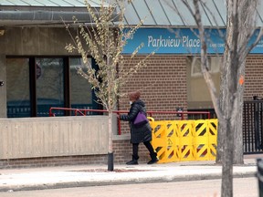 An employee approaches a barrier at the entrance to Parkview Place personal care home on Edmonton Street in Winnipeg on Sunday, Oct. 25, 2020.