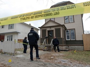 Forensics officers with the Winnipeg Police Service investigate a homicide in the 500 block of Furby Street in Winnipeg on Sunday.