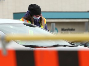 Screening is conducted at the COVID-19 drive-thru testing site on Main Street in Winnipeg on Monday.