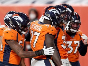 The Denver Broncos celebrate an interception during the fourth quarter against the Miami Dolphins at Empower Field At Mile High in Denver, Nov. 22, 2020.
