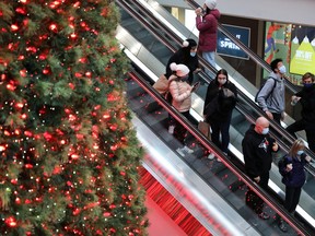 Shoppers wearing mandatory masks pass the Christmas Tree at Toronto's Eaton Centre mall, two days before COVID-19 restrictions are reintroduced to Toronto and Peel regions, Nov. 21, 2020.