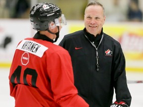 Jake Virtanen has a laugh with coach Dave Lowry during Hockey Canada's National Teams' Summer Showcase at Winsport in Calgary, Alta., on Saturday, Aug. 1, 2015.
