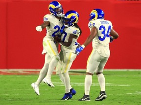 Rams players Cam Akers (23), Darrell Henderson (27), and Malcolm Brown (34) celebrate following a touchdown during the third quarter against the Buccaneers at Raymond James Stadium in Tampa, Fla., Monday, Nov. 23, 2020.