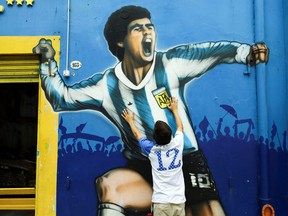A fan mourns the death of soccer legend Diego Maradona, outside the Alberto J. Armando "La Bombonera" stadium, in Buenos Aires, Argentina, Nov. 25, 2020.