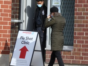 Winnipeggers enter Shoppers Drug Mart where a flu shot clinic is being offered. A Winnipeg pharmacist says they have not been resupplied with doses of the flu vaccine in almost a month.