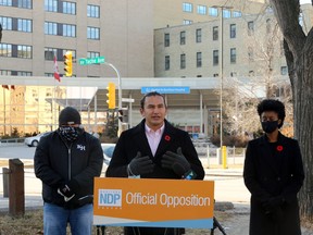 NDP Leader Wab Kinew (centre), with health critic Uzoma Asagwara (right) and Chris Graves, King's Head Pub owner, speaks about the province's COVID-19 response near St. Boniface Hospital in Winnipeg on Sunday, Nov. 1, 2020.
