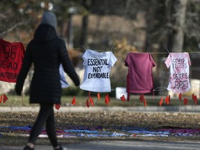 A laundry line with hospital smocks bearing criticisms of Manitoba's COVID-19 response was placed in front of Manitoba Premier Brian Pallister's home in Winnipeg on Saturday.