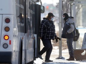 Transit passengers near a bus, on Main Street, in Winnipeg.