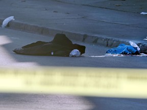 A dark jacket and a pile of compress bandages on top of a pool of blood after a shooting on Isabel Street at Elgin Avenue in Winnipeg on Monday.