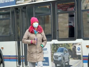 A woman wearing a face mask walks on Main Street in Winnipeg on Tuesday, Nov. 17, 2020.