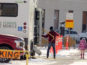 People exit the mobile COVID-19 testing site on Portage Avenue in Winnipeg on Monday.