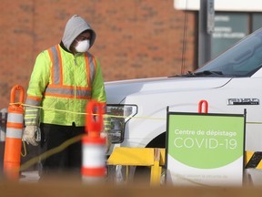 A person wears a mask while directing people across a parking lot to a mobile COVID-19 testing site in Winnipeg on Wednesday, Nov. 25, 2020. Chris Procaylo/Winnipeg Sun