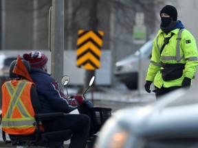 A G4S security guard member (right) crosses Memorial Boulevard in Winnipeg on Thurs., Nov. 26, 2020. The firm was hired to help enforce health orders. Kevin King/Winnipeg Sun/Postmedia Network