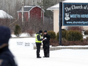 Minister Tobias Tissen (right) reviews documents presented by RCMP following an attempted Sunday service at Church of God, south of Steinbach, Man., on Sunday, Nov. 29, 2020.