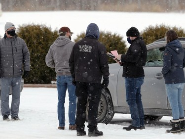 A man is given a ticket by Manitoba Justice officials for disobeying public health orders outside Church of God, south of Steinbach, Man., on Sunday, Nov. 29, 2020.