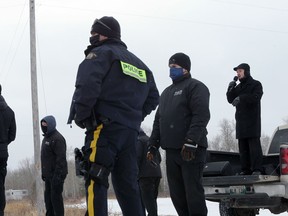 Minister Tobias TIssen (right) speaks from the back of a pickup truck to people gathered on the highway after RCMP blocked a planned drive-by Sunday service at Church of God, south of Steinbach, Man., on Sunday.