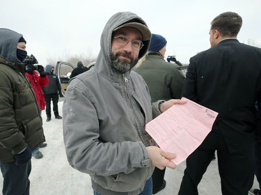 A man displays a ticket he was given by Manitoba Justice officials for disobeying public health orders outside Church of God, south of Steinbach, Man., on Sun., Nov. 29, 2020.