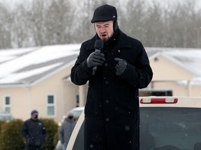 Minister Tobias Tissen leads a prayer from the back of a pickup truck after RCMP blocked the entrance at Church of God, south of Steinbach, Man., on Sunday, Nov. 29, 2020.