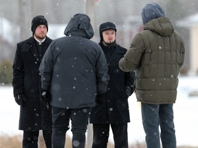 Government officials speak to Minister Tobias Tissen (second from right) and another representative of Church of God, south of Steinbach, Man., on Sunday, Nov. 29, 2020.