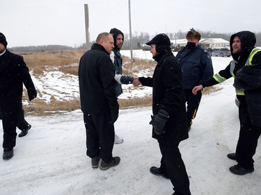 Minister Tobias Tissen (centre right) from Church of God shakes hands with Patrick Allard, organizer with a group called Manitoba Together, which has protested public health orders, outside the church south of Steinbach, Man., on Sunday, Nov. 29, 2020.
