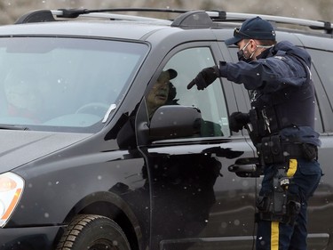 An RCMP officer tells a driver he cannot park on the side of the highway outside Church of God, south of Steinbach, Man., on Sunday, Nov. 29, 2020.