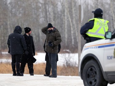 Manitoba Justice officials speak with a representative of Church of God with RCMP standing by on the highway in front of the property south of Steinbach, Man., on Sunday, Nov. 29, 2020.