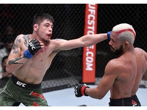 LAS VEGAS, NEVADA - DECEMBER 12: In this handout image provided by UFC, (L-R) Brandon Moreno of Mexico punches Deiveson Figueiredo of Brazil in their flyweight championship bout during the UFC 256 event at UFC APEX on December 12, 2020 in Las Vegas, Nevada.