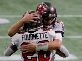 Tom Brady of the Tampa Bay Buccaneers celebrates with Leonard Fournette after a first down against the Atlanta Falcons during the fourth quarter in the game at Mercedes-Benz Stadium on December 20, 2020 in Atlanta, Georgia.