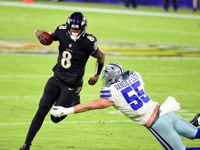 Baltimore Ravens quarterback Lamar Jackson, left, avoids the tackle of Dallas Cowboys linebacker Leighton Vander Esch in the third quarter at M&T Bank Stadium in Baltimore, Md., Dec. 8, 2020.