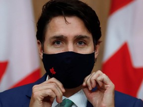 Canadian Prime Minister Justin Trudeau puts on a mask at a news conference held to discuss the country's coronavirus disease (COVID-19) response in Ottawa, Ontario, Canada. November 6, 2020. REUTERS/Patrick Doyle ORG XMIT: GGG-OTW111