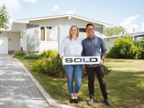 Paige Kutzner and Richard Monzon hold up the sold sign in front of the house Shayna Hogan helped them purchase this summer. DAVID JATIVA/handout