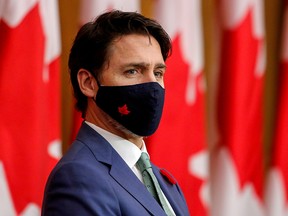 Prime Minister Justin Trudeau listens while wearing a mask at a news conference held to discuss the country's coronavirus response in Ottawa November 6, 2020.