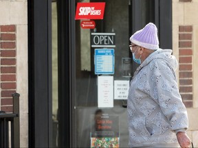 A man walks past a restaurant door in Winnipeg on Monday, Nov. 2, 2020.