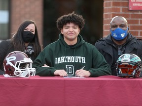 Zach Lytle, bound for Dartmouth University, takes part in a signing ceremony at St. Paul’s Collegiate yesterday with mom Rychelle, and dad Dean.
