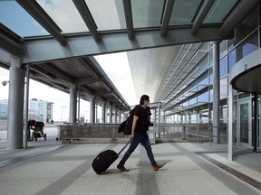 A man wearing a mask approaches the terminal at Winnipeg international airport on Mon., July 27, 2020. Masks will be mandatory in public areas of the airport terminal for passengers, visitors and employees beginning Wednesday.