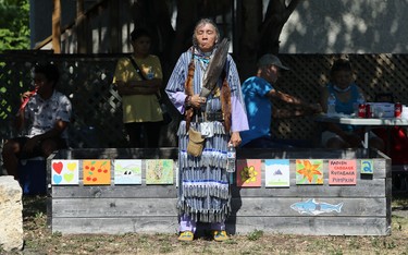 A dancer stands solemnly during a prayer at a demonstration pow pow held by 1JustCity in Agnes Street Green Space near its St. Matthews Maryland Community Ministry in Winnipeg on Thurs., Aug. 20, 2020. Intended to showcase and honour Indigenous culture, audience members were able to share in a lunch but unable to join in the dancing as in previous years. Kevin King/Winnipeg Sun/Postmedia Network