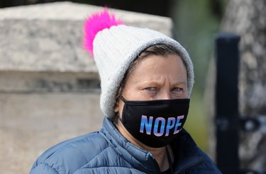 A woman makes a statement with her mask and tuque while standing at a bus stop on Main Street in Winnipeg on Wed., Sept. 9, 2020. Kevin King/Winnipeg Sun/Postmedia Network