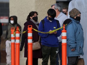 People line up to enter a grocery store in Winnipeg on Saturday.