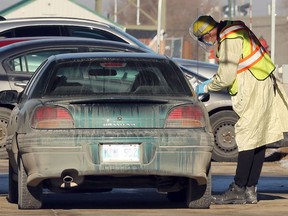 An employee speaks with a person in a vehicle at the drive-thru COVID-19 testing site run by the Minor Illness and Injury Clinic at Red River College on Notre Dame Avenue in Winnipeg on Sunday.