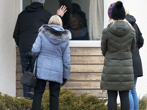 A group of people visit a resident at Charleswood Care Centre on Roblin Boulevard in Winnipeg through a window on Tues., Dec. 8, 2020. Kevin King/Winnipeg Sun/Postmedia Network