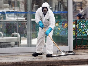 Excess disinfectant is removed from a sidewalk after an Osborne Village bus shelter was sanitized on Tues., Dec. 8, 2020. Kevin King/Winnipeg Sun/Postmedia Network