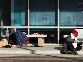 A woman has a bite to eat outside Siloam Mission on Princess Street in Winnipeg on Thursday, Dec. 10, 2020.