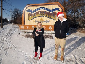 Lianne Tregebov and Olivier Chakroun of Charleswood Cheer pose by the Welcome to Charleswood sign on Roblin Boulevard in Winnipeg on Sunday.