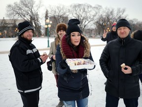 Event organizer Bryna Wittinger (centre) hands out cupcakes during her Reason for the Season event at the Manitoba Legislative Building in Winnipeg on Sunday.