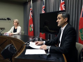 Dr. Jazz Atwal (right), Manitoba's acting deputy chief public health officer, speaks during a COVID-19 briefing at the Manitoba Legislative Building in Winnipeg with chief nursing officer Lanette Siragusa listening, on Monday, Dec. 21, 2020.