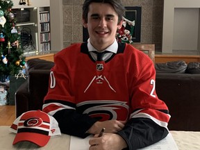 Forward Seth Jarvis signs his Carolina Hurricanes contract at his Winnipeg home last week. The Hurricanes signed Jarvis, their first-round pick in the 2020 NHL Entry Draft, to a three-year, entry-level contract, the team announced Monday.