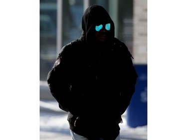 A man's sunglasses reflect bright white snow while he walks through campus at the University of Winnipeg.   Friday, Jan. 10, 2020