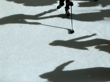 A sunny winter day in Winnipeg.  Skaters cast shadows on an outdoor ice surface, while one person stickhandler a puck through the crowd.  Thursday, Feb. 20, 2020.